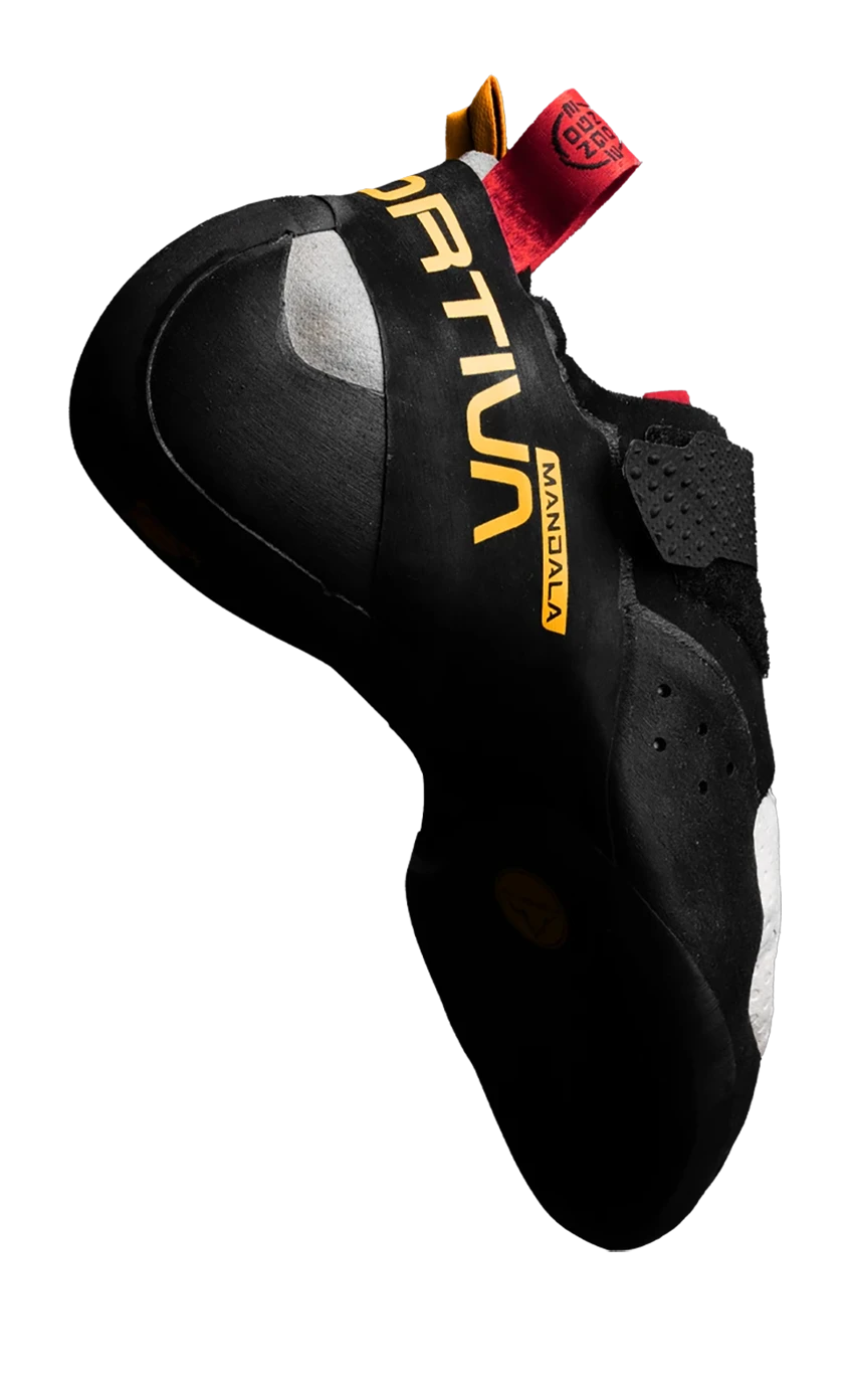 The perfect companion for Les centres d'escalade de bloc par excellence à Montréal, this black climbing shoe boasts vibrant orange and yellow accents, a Velcro strap for easy adjustment, and a rugged rubber sole for exceptional grip.
